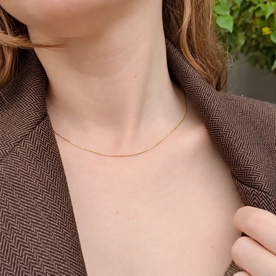 Mulher usando corrente veneziana delicada de ouro no pescoço