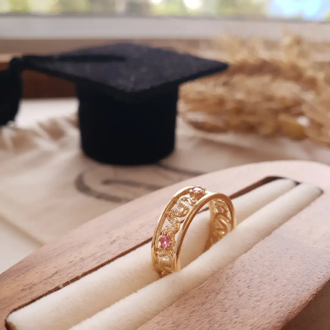 Anel de formatura em ouro ao lado de um capelo