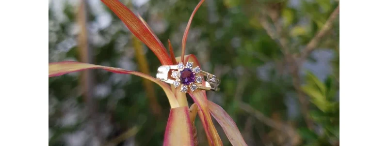 Anel de formatura em ouro com pedra lilás central de 4mm e ao redor 8 zircônias de 1,5mm.